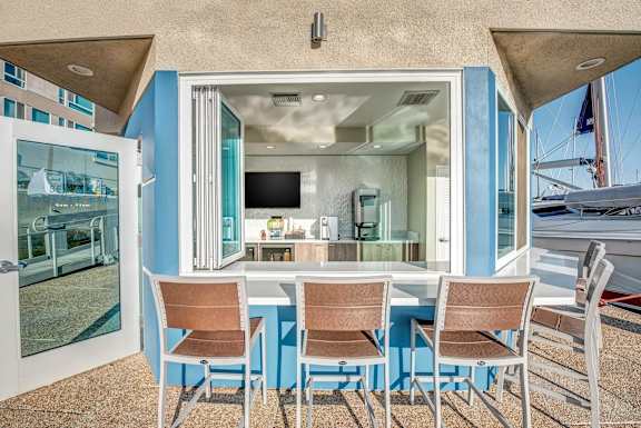 A dining table with chairs is set up outside a house.