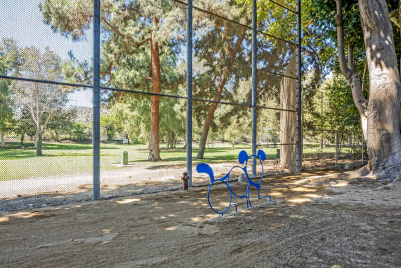 a blue park bench sitting in front of a fence