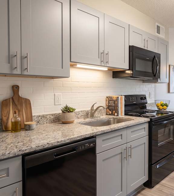 A kitchen with a black oven and a black microwave above the stove.