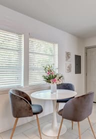 a dining room with a white table and chairs     and a door