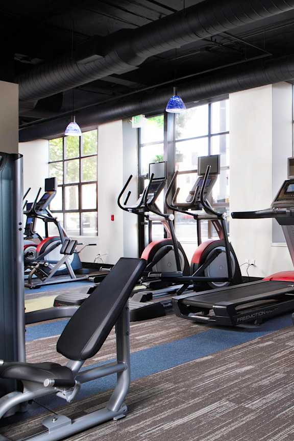 A gym with treadmills, elliptical machines, and other cardio equipment at Skye at Belltown Apartments, Seattle, 98121