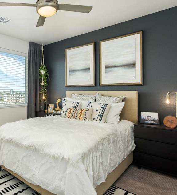 A bedroom with a large bed and a ceiling fan.