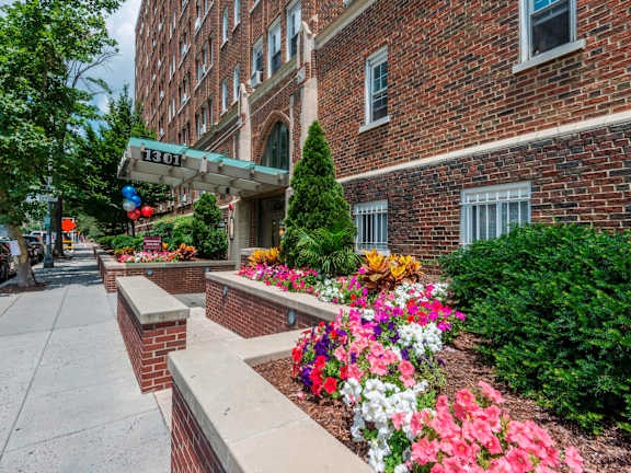 A flower bed in front of a brick building with a sign that reads 1301.