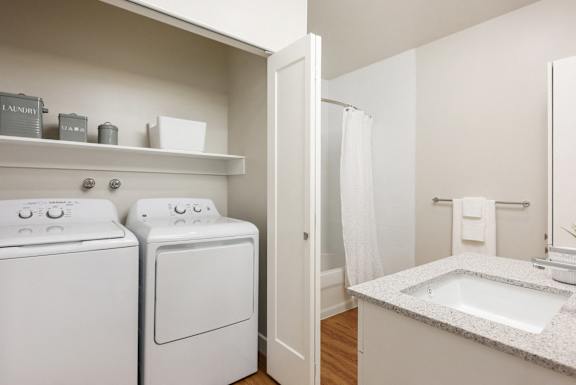 a utility room with a washer and dryer and a bathroom with a sink