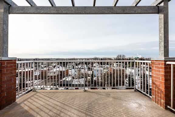 a balcony with a view of a city and the ocean