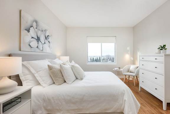 a bedroom with a large white bed and a window