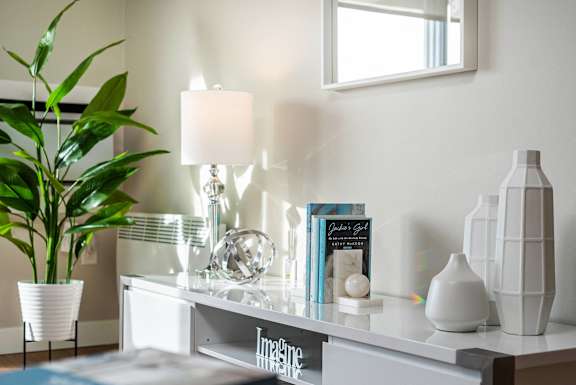 a white desk with a lamp and books on it