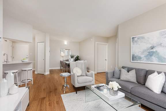 a living room with a gray couch and a glass coffee table