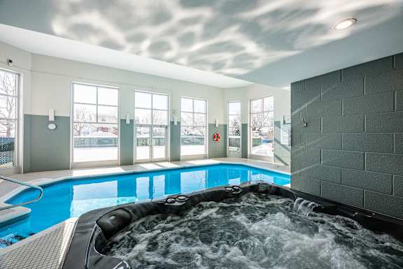 a large jacuzzi in a pool with a cloudy sky on the ceiling