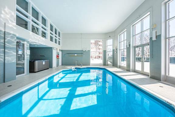 a swimming pool in the middle of a building with large windows