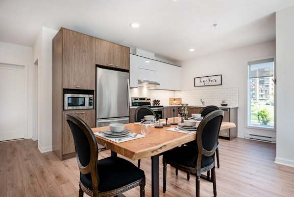 a kitchen and dining room with a wooden table and chairs