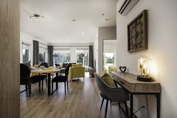 a living room and dining room with a table and chairs and a large window