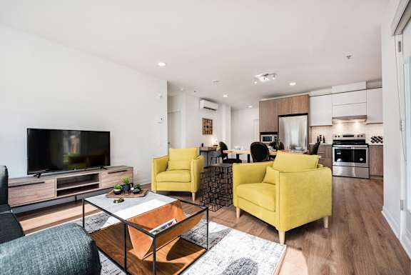 a living room with two yellow couches and a coffee table