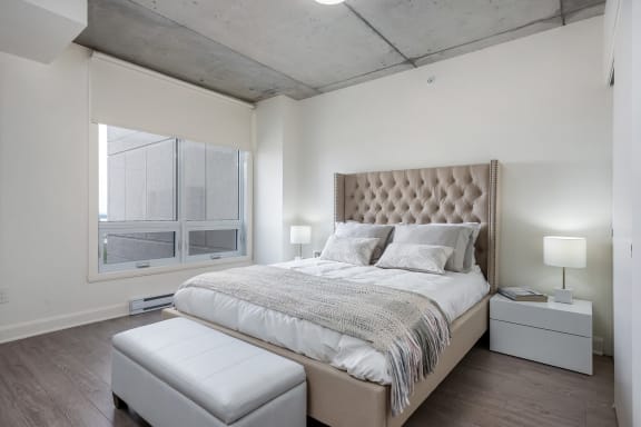 a bedroom with a bed and a large window