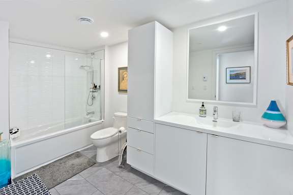 A white bathroom with a glass shower stall and a toilet.