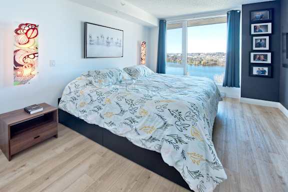 A bedroom with a large bed and a view of the city.