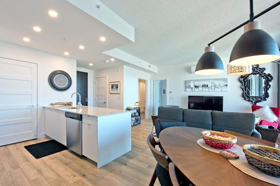 A modern kitchen with a wooden table and chairs.
