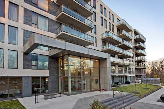 A modern building with a glass entrance and a number 235 on it.