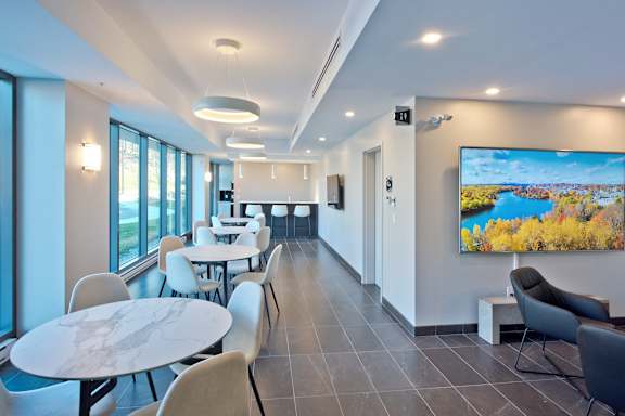 A modern lounge area with a large screen TV and comfortable seating.