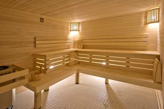 A wooden sauna with benches and lights.