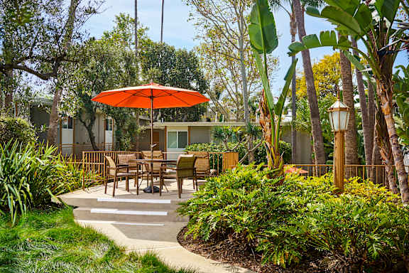 a patio with tables and an umbrella at West Park Village, Los Angeles, California