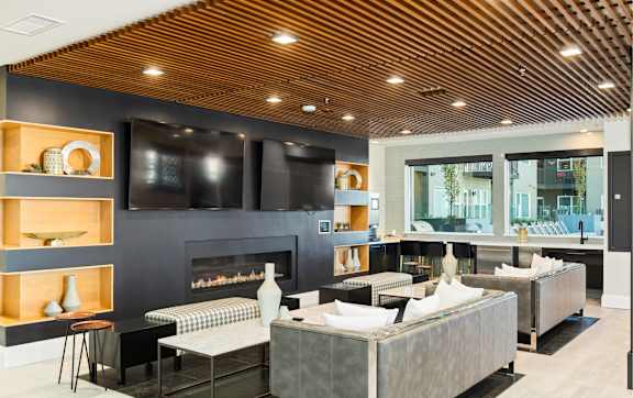 A modern living room with a fireplace and a large grey sofa.