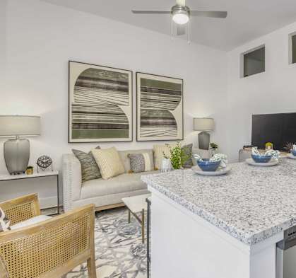 a kitchen with a counter top next to a living room