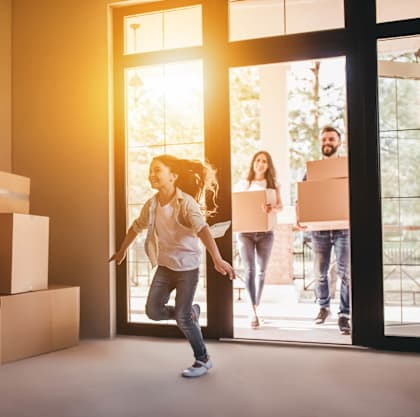 a young girl running in a room full of boxes