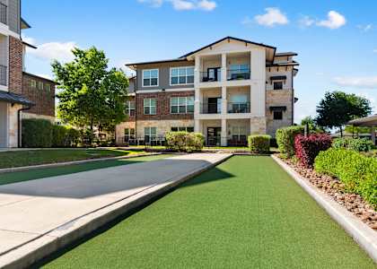 A sunny day at a residential area with apartment buildings and a green lawn.