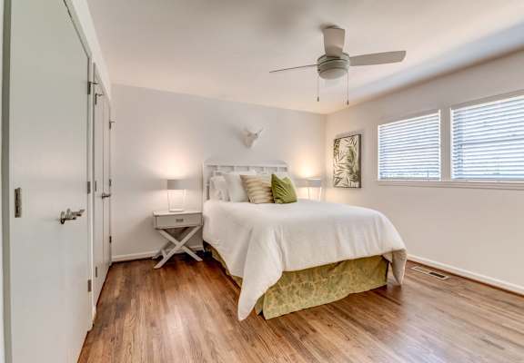 a bedroom with a bed and a ceiling fan
