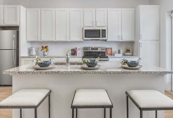 a kitchen with a marble counter top with three stools