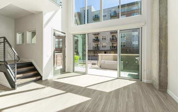 A modern interior with a staircase and glass doors leading to a balcony.