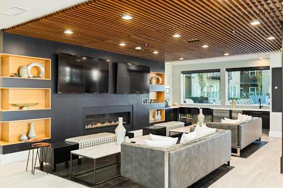 A modern living room with a fireplace and a large grey sofa.