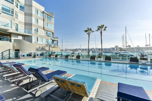 a swimming pool with lounge chairs and a building in the background at Esprit Apartments, Marina del Rey, 90292