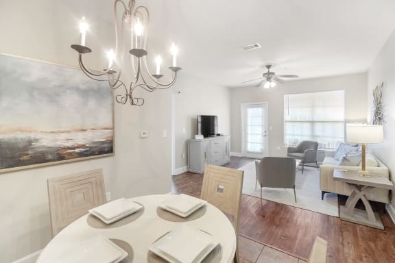 a dining room and living room with a table and chairs and a ceiling fan  at Quail Ridge Highlands Apartment Homes, Bartlett, Tennessee