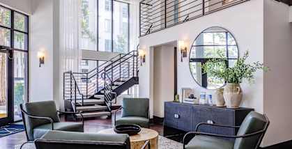 A room with a staircase and a large mirror.