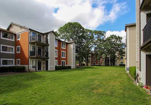 Apartment complex with a green lawn in front.