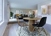 Thumbnail 6 of 6 - A modern dining room with a round table and chairs.