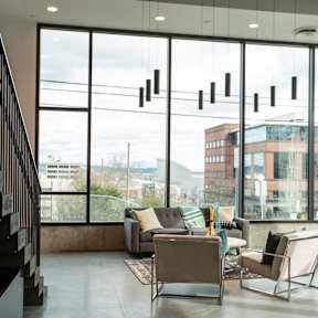 a living room with large windows and a couch and chairs at Analog Tacoma, Tacoma, Washington