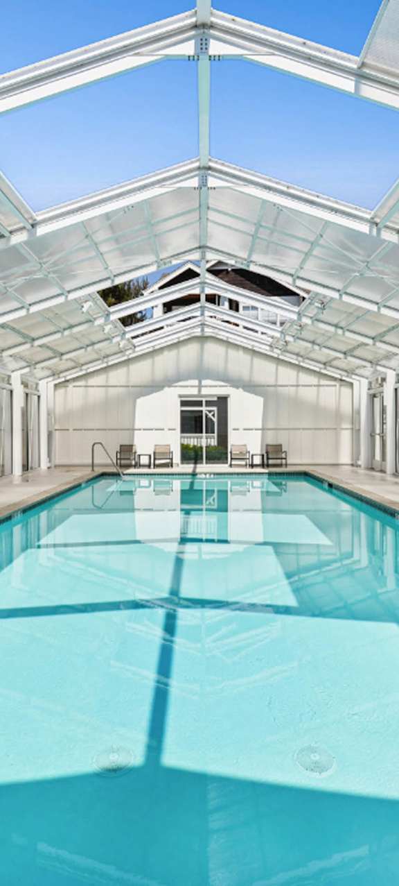 A large indoor swimming pool with a glass ceiling.
