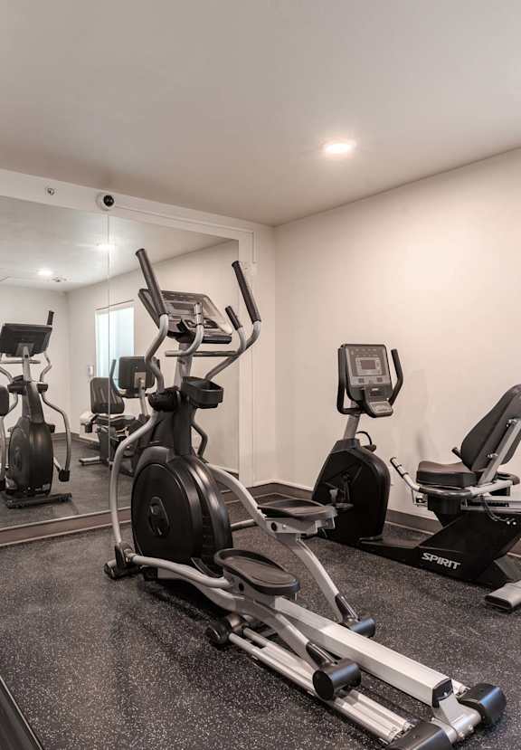 a gym with several machines and a television on the wall at VINTAGE AT BEND, Bend, OR 97701