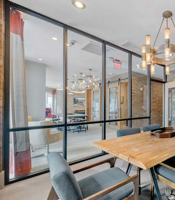 A dining room with a wooden table and grey chairs.
