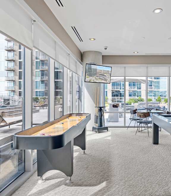 A billiard table is in the middle of a room with a pool table and a television.