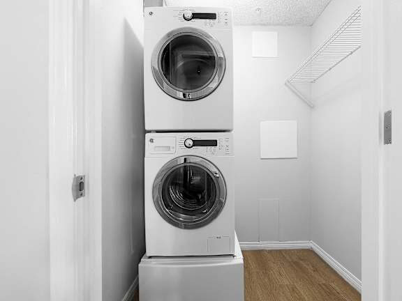 a washing machine and dryer in a white laundry room