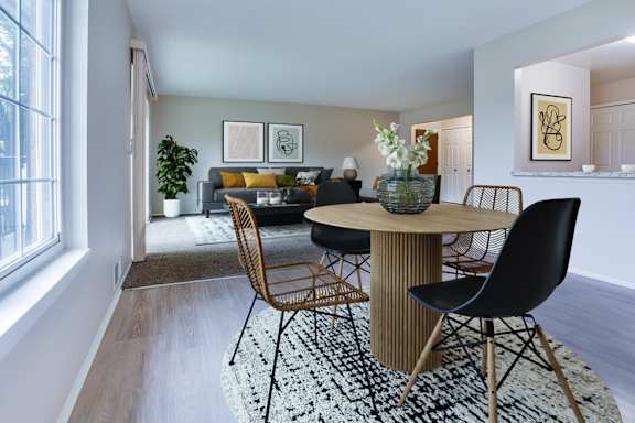 A modern dining room with a round table and chairs.
