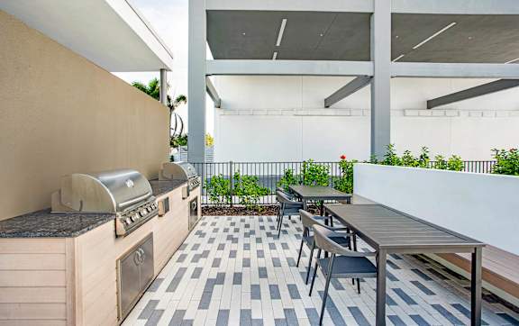 A patio with a grill and seating area.