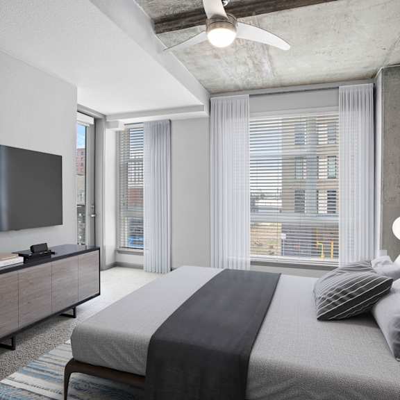 A modern bedroom with a large bed and a flat screen TV.
