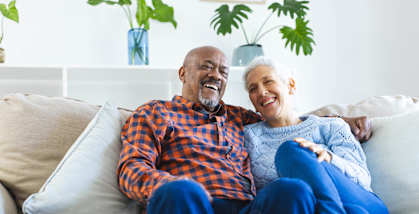 An older couple is sitting on a couch together.