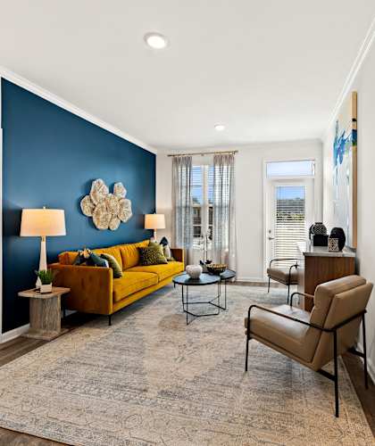 a living room with a blue accent wall and a yellow couch