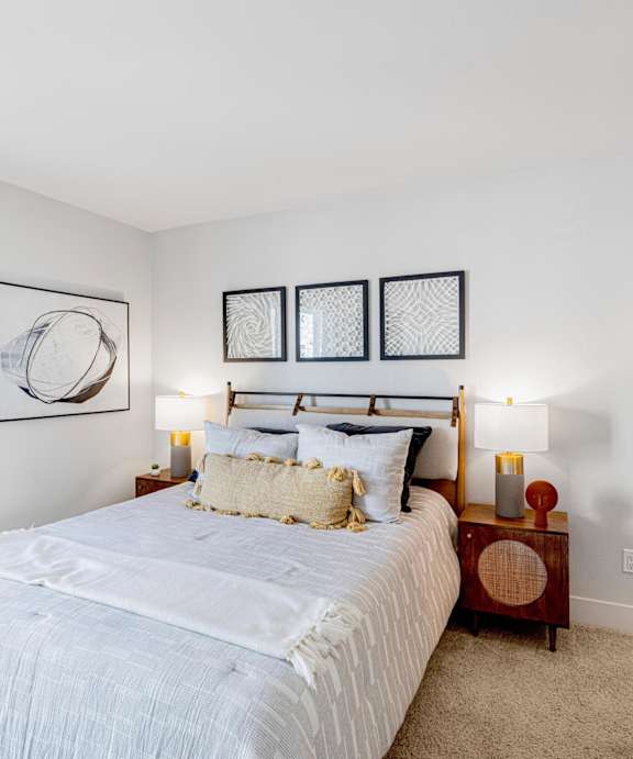 A bedroom with a large bed and a window with curtains.
